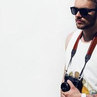 close-up do homem jovem hippie com câmera ao ar livre. foto