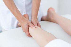 fisioterapeuta fazendo massagem nas pernas foto