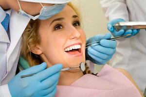 uma jovem mulher cercada por dentistas no dentista