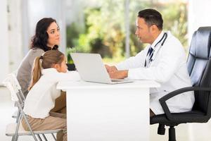 médico pediatra falando com a mãe do paciente foto