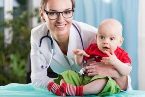 pediatra e paciente durante consulta médica foto