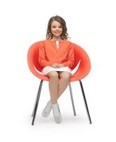 menina pré-adolescente em roupas casuais, sentado na cadeira foto