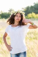 menina adolescente com uma coroa de margaridas no campo foto