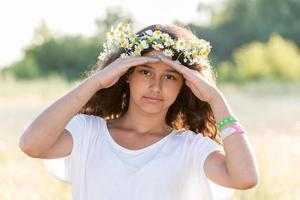 menina adolescente com uma coroa de margaridas no campo foto