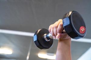 feche o haltere preto na sala de fitness coberta., tailândia. foto