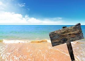 placa de madeira na praia e mar foto