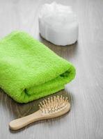 escova de cabelo e esponja de banho com toalha foto