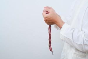 fechar a mão segurando um tasbih ou contas de oração foto