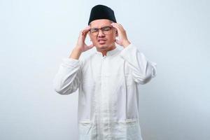 jovem muçulmano asiático segurando sua cabeça sofrendo de dor de cabeça com espaço de cópia foto