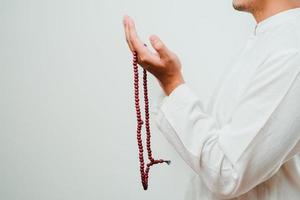 fechar a mão segurando um tasbih ou contas de oração foto