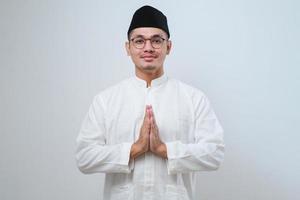 homem muçulmano asiático de óculos sorrindo para dar saudação durante a celebração do ramadã e eid al fitr foto