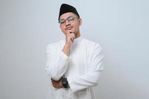 homem muçulmano asiático fazendo gesto de pensamento, procurando uma ideia foto