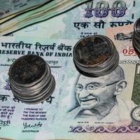 raras moedas de rúpias antigas do banco indiano caindo em notas de moeda, caindo moeda de rúpia indiana em notas de cem rúpias, moedas de moeda indiana caindo foto