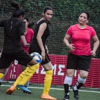 nova delhi, índia - 01 de julho de 2018 - mulheres futebolistas do time de futebol local durante o jogo no campeonato regional de derby em um campo de futebol ruim. momento quente da partida de futebol no estádio de campo verde grama foto