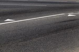 close-up de uma estrada de asfalto com marcações de estrada branca foto