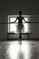 uma bailarina encantadora em uma roupa posa elementos de balé em um cocar em um estúdio fotográfico foto