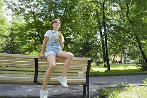 uma adolescente em uma caminhada em um dia de verão no parque para desfrutar de sorvete foto