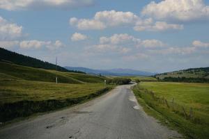 fita da estrada entre as encostas das montanhas nas extensões de altai em um dia de verão foto