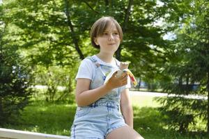 uma adolescente em uma caminhada em um dia de verão no parque para desfrutar de sorvete foto