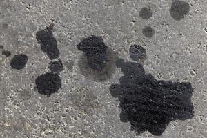 close-up de manchas de óleo de carro na estrada foto