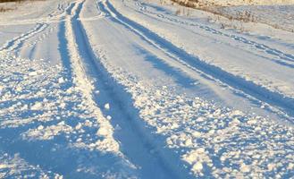 trilha em uma estrada coberta de neve foto