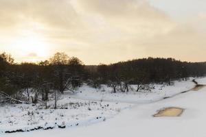 Rio coberto de neve ao pôr do sol foto