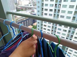 donas de casa asiáticas secando roupas na varanda de um condomínio ou apartamento foto