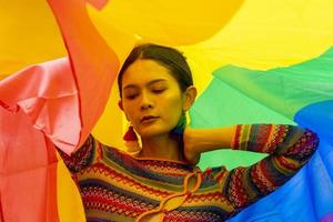 mulher modelo transgênero de elegância em traje colorido de bandeira do arco-íris está dançando no desfile homossexual para o mês do orgulho lgbtq e saindo do conceito do armário para o conceito de igualdade e liberdade sexual foto