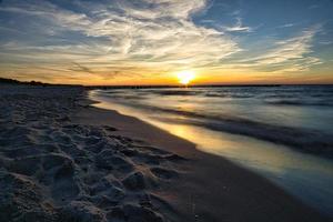 pôr do sol na praia de zingst no mar báltico foto