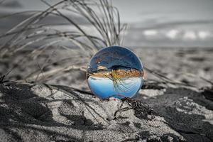 globo de vidro na praia do mar báltico em zingst em que a paisagem é retratada. foto