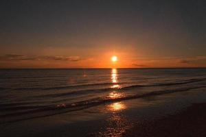 pôr do sol na praia de blavand na dinamarca. andando à noite em grande atmosfera de luz foto