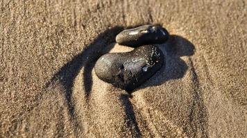 pedra em forma de coração na areia da praia no mar Báltico foto