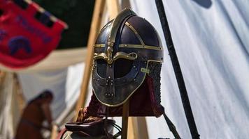 equipamento medieval, capacete, luva de metal, armadura. espetáculo medieval em tempos passados foto