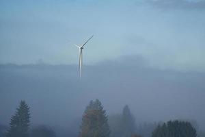 moinho de vento na paisagem nevoenta. energia renovável para um futuro ambientalmente consciente foto