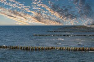 groynes na praia do mar báltico em zingst. ondas quebram na madeira foto