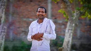retrato de jovem agricultor indiano sorridente em pé na rua foto