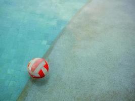 um vôlei aquático flutuando na água na piscina em um dia chuvoso foto