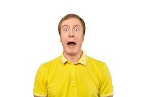 jovem surpreso com expressão facial engraçada em camiseta amarela, fundo branco isolado foto