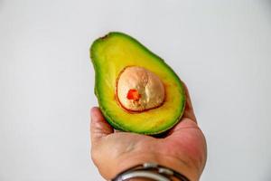 abacate na mão esquerda foto