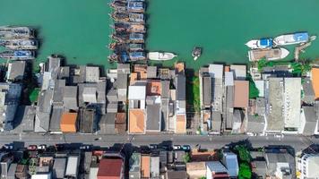 barcos de pesca em uma vila de pescadores refletindo na água. vida de uma vila de pescadores na costa de songkhla, tailândia, da vista aérea do drone. foto