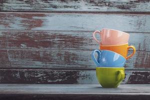 xícaras de café coloridas de tom vintage com espaço de cópia na placa de madeira, xícara de café empilhada foto