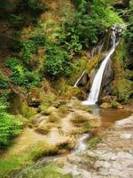 uma grande cachoeira sobre um corpo de água foto