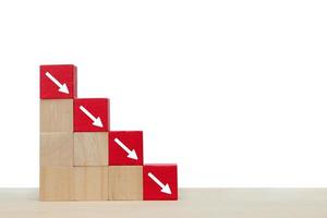 seta apontando para baixo no bloco de madeira vermelho. símbolo da queda de investimentos ou negócios foto