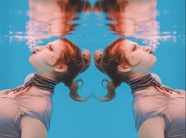 retrato de arte surreal de jovem de vestido cinza e cachecol frisado debaixo d'água na piscina foto