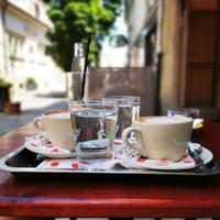 uma xícara de café e uma água mineral em uma mesa foto