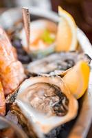 ostras frescas em um prato com outros frutos do mar. foto