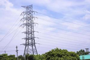 poste de eletricidade de alta tensão sob o céu azul nublado foto