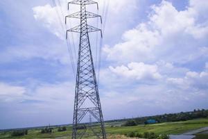 poste de eletricidade de alta tensão sob o céu azul nublado foto