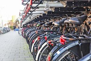 centro da cidade de amsterdã com bicicletas estacionadas na beira da estrada foto