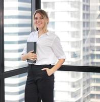 retrato de uma empresária segurando o notebook no escritório moderno foto